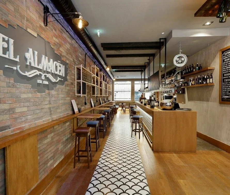 Interior del bar El Almacén con paredes de ladrillo visto, Gijón